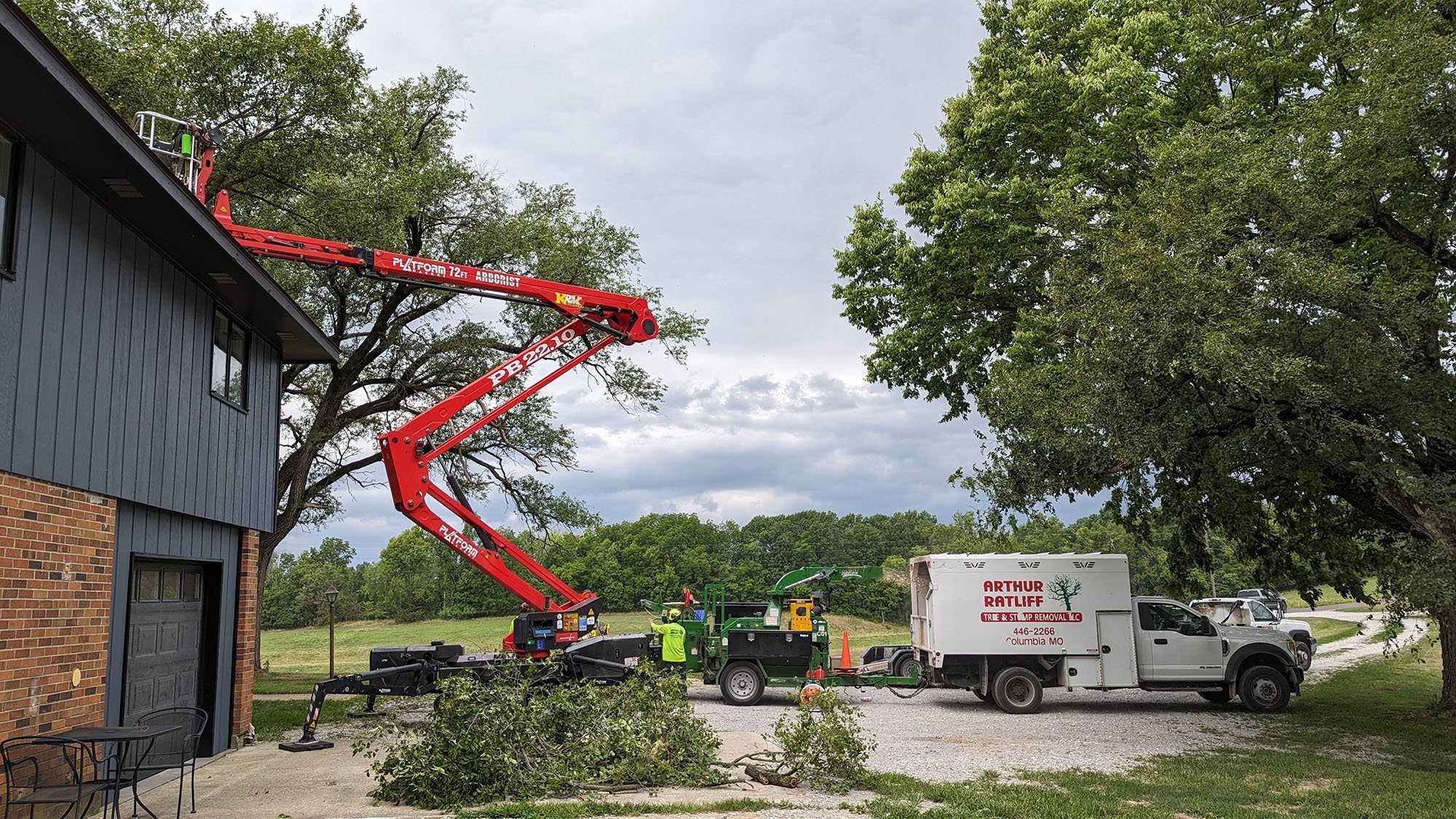 Team using cherry picker to remove debris on home